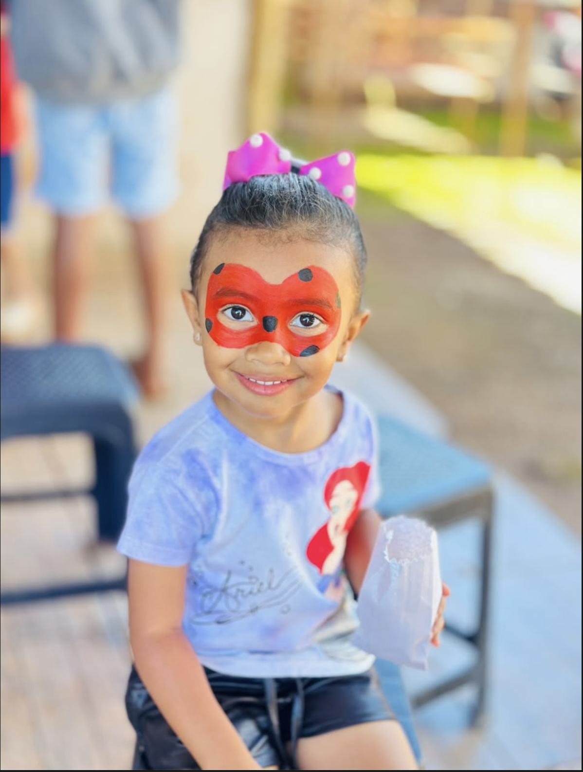 Criança com pintura facial colorida durante a celebração.