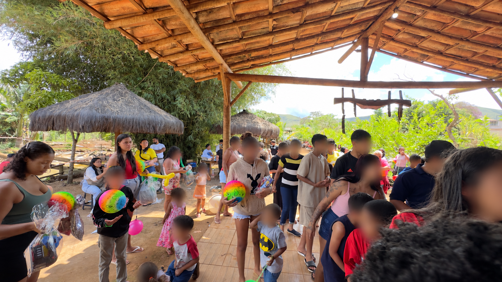 Crianças e famílias participam da celebração. Rostos desfocados para preservar a identidade das crianças.