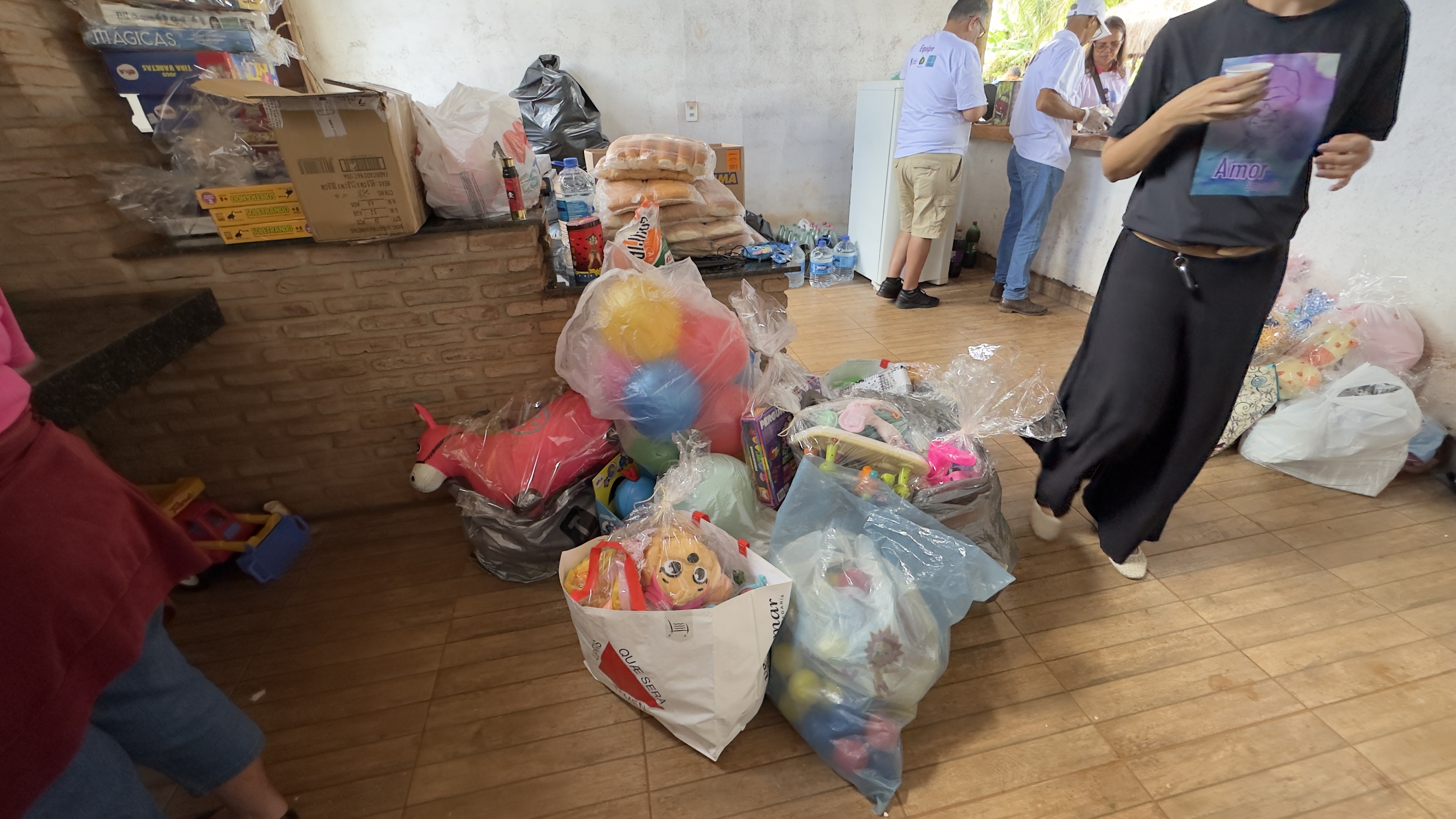 Brinquedos arrecadados e materiais organizados para a festa.